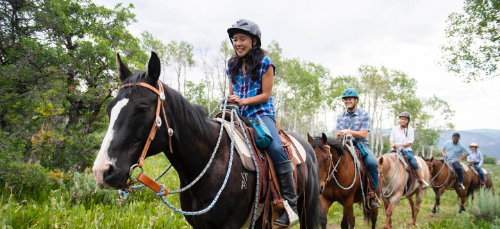 Family riding horses in a nose-to-tail ride