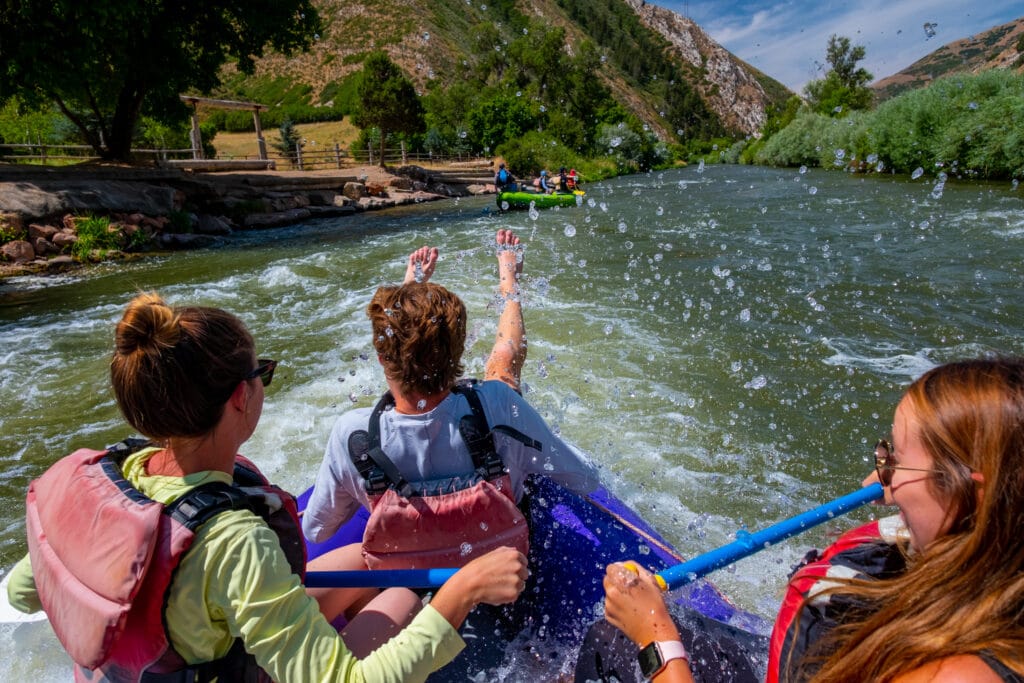 white water rafting in park city utah. 
big splash and happy people on board the raft