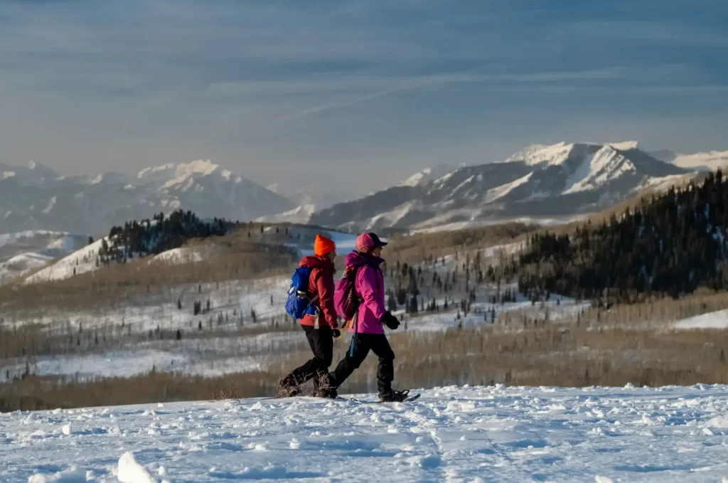 Two people snowshoeing at Guardsman Pass with a beautiful view